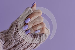 Female\'s hand with delicate nails of trendy lavender color