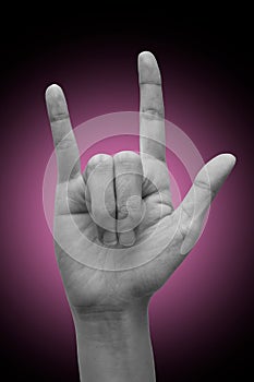 Female`s hand doing sign language `I love you`. isolated on gradient background.  Metal sign. Communication concept