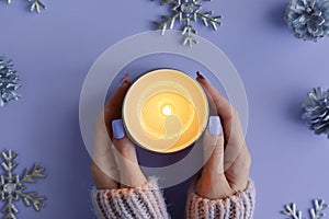 Female's hands holding a burning soy candle