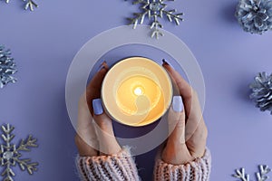 Female's hands holding a burning soy candle photo