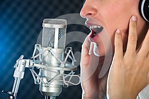 Female`s Open Mouth With Red Lipstick In Front Of Microphone photo