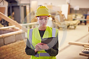 Female Safety Inspector With Digital Tablet At Construction Site