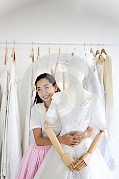 Female sales assistant in bridalwear store wedding dress in a sh