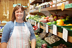 Female Sales Assistant At Vegetable Counter Of Farm Shop