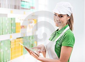 Female sales clerk with tablet at supermarket photo