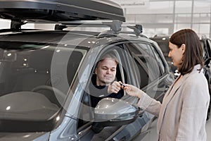 female salesperson and car rental helps with the purchase. signing a trade-in contract and handing over keys