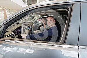 female salesperson and car rental helps with the purchase. signing a trade-in contract and handing over keys