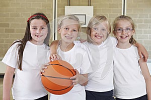 Female School Sports Team In Gym With Basketball