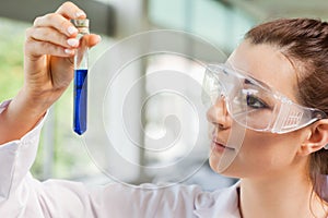 Female science student looking at a test tube