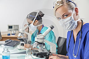 Female Scientific Research Team Using Microscopes in Laboratory