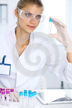 Female scientific researcher in laboratory studying substances or blood sample. Medicine and science concept