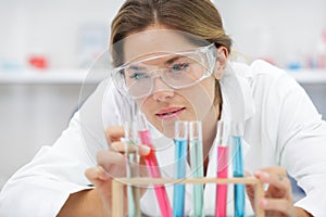 female scientist analysing rack test tubes