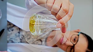 Female scientist analyzing behavior of dangerous small plastic particles on a golden glitter sample