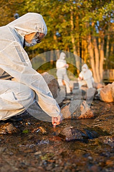 Female scientist collecting water sample from sea with her team