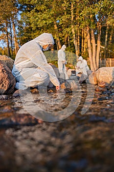 Female scientist collecting water sample from sea