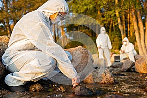 Female scientist collecting water sample from sea