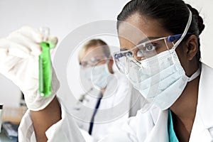 Female Scientist With Green Solution In Laboratory