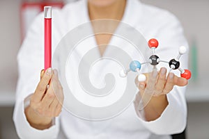 Female scientist holding dna molecule and test tube