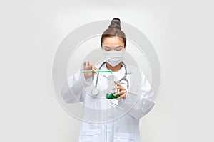 Female scientist in lab coat with chemical glassware. Isolated on white