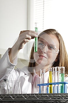 Female scientist in the lab with test tube, vertic