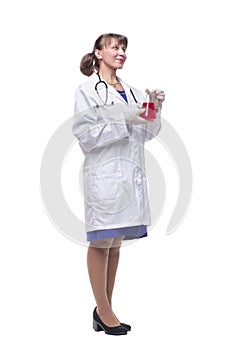 Female scientist looking at beaker of red liquid