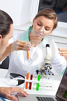 Female scientist looking at liquid in test tube