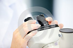 Female scientist looking through a microscope