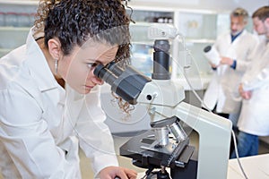 Female scientist looking into microscope