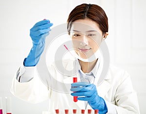 Female scientist looking at test tube