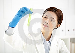 female scientist looking at test tube