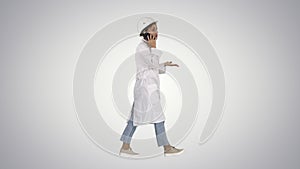 Female scientist making a call walking on gradient background.