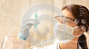 Female scientist with mask and laboratory glasses analyzes a test tube on digital background with dna and holographic images