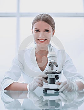 Female scientist with a microscope works in the laboratory