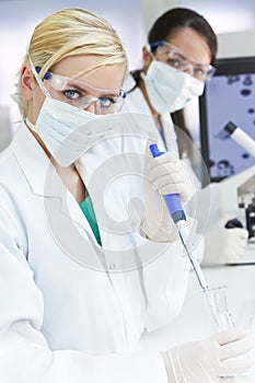 Female Scientist Pipette & Flask In Laboratory