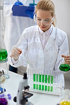 Female scientist with pipette and tubes making test
