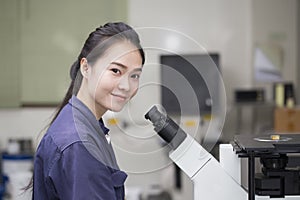 Female scientist preparing a microscope in laboratory