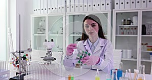 Female scientist or student holding molecular structure model in lab