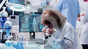 Female scientist uses a microscope to analyze some sample