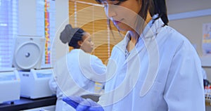 Female scientist using digital tablet in laboratory 4k