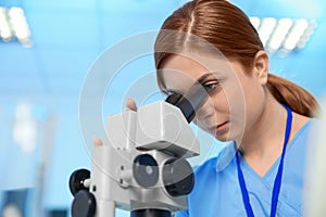 Female scientist using microscope in chemistry laboratory