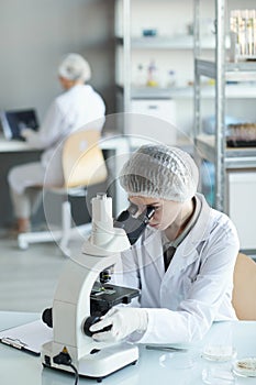 Female Scientist Using Microscope in Laboratory