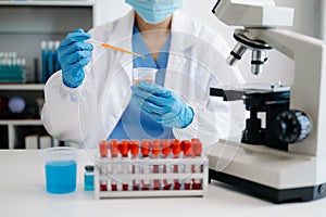 female scientist working with micro pipettes analyzing biochemical samples, advanced science chemical laborator photo