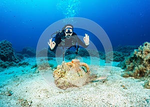 Female scuba diver in front of an ancient Greek, sunken Amphora in the Aegean Sea
