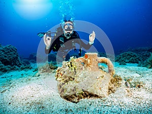 Female scuba diver in front of an ancient, sunken in the Aegean Sea