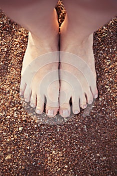 Female sea natural style pedicure feet on summer shore sand on sunny beach. meditation yoga at the sea