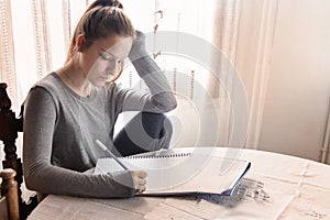 A female secondary school student doing homework at home.