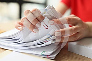 Female secretary looks through fastened papers in office