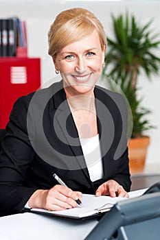 Female secretary writing on notepad