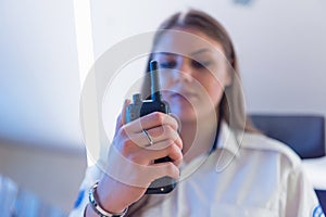 Female security guard operator talking on the phone, calling in the alarming event to the external team of field force agents