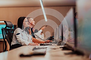 Female security guard operator talking on the phone while working at workstation with multiple displays Security guards